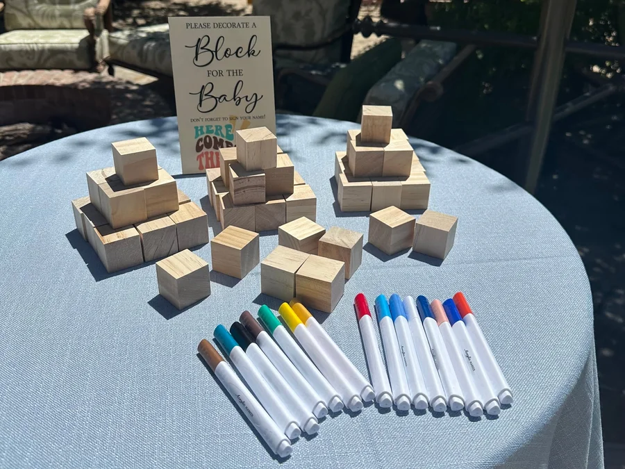 Baby shower table with wooden blocks and colored markers for a guest activity