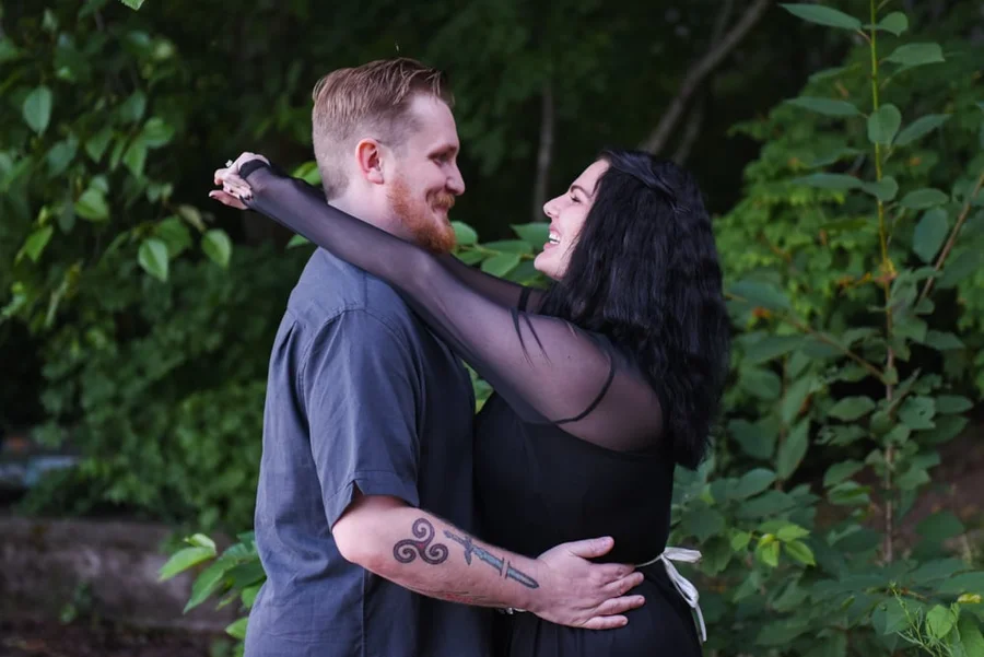 Couple dancing close among green foliage during an engagement shoot